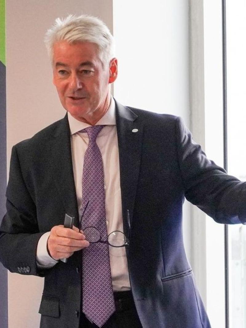 Prof. McNamee is speaking from the podium giving a presentation.