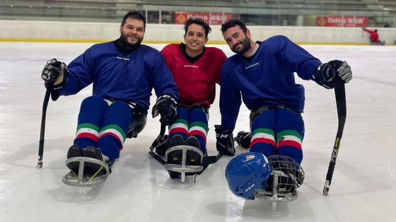 Three male Italian Para ice hockey athletes posing on the ice